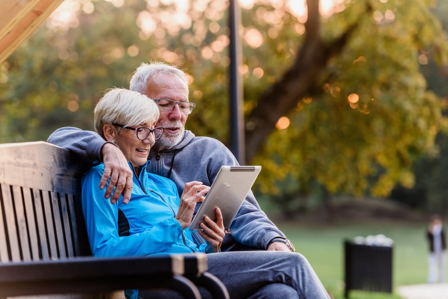 Older man and woman holding a tablet looking financial advisor websites