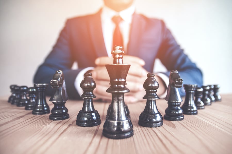 Financial advisor staring at chess pieces representing financial advisor marketing strategy