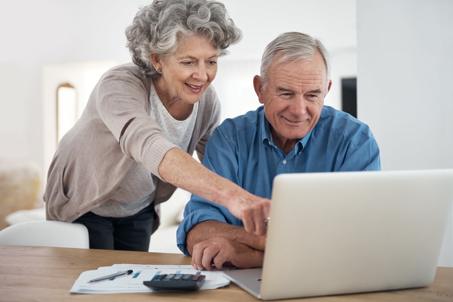retired couple looking at laptop computer researching financial advisors in their area