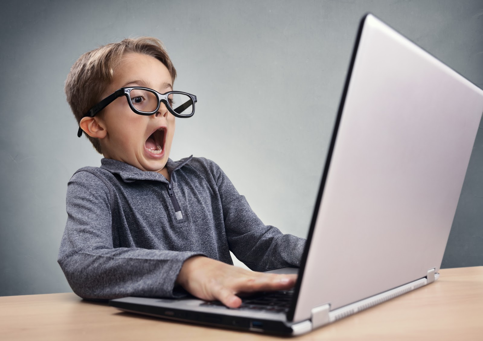 child on laptop scared by what he sees
