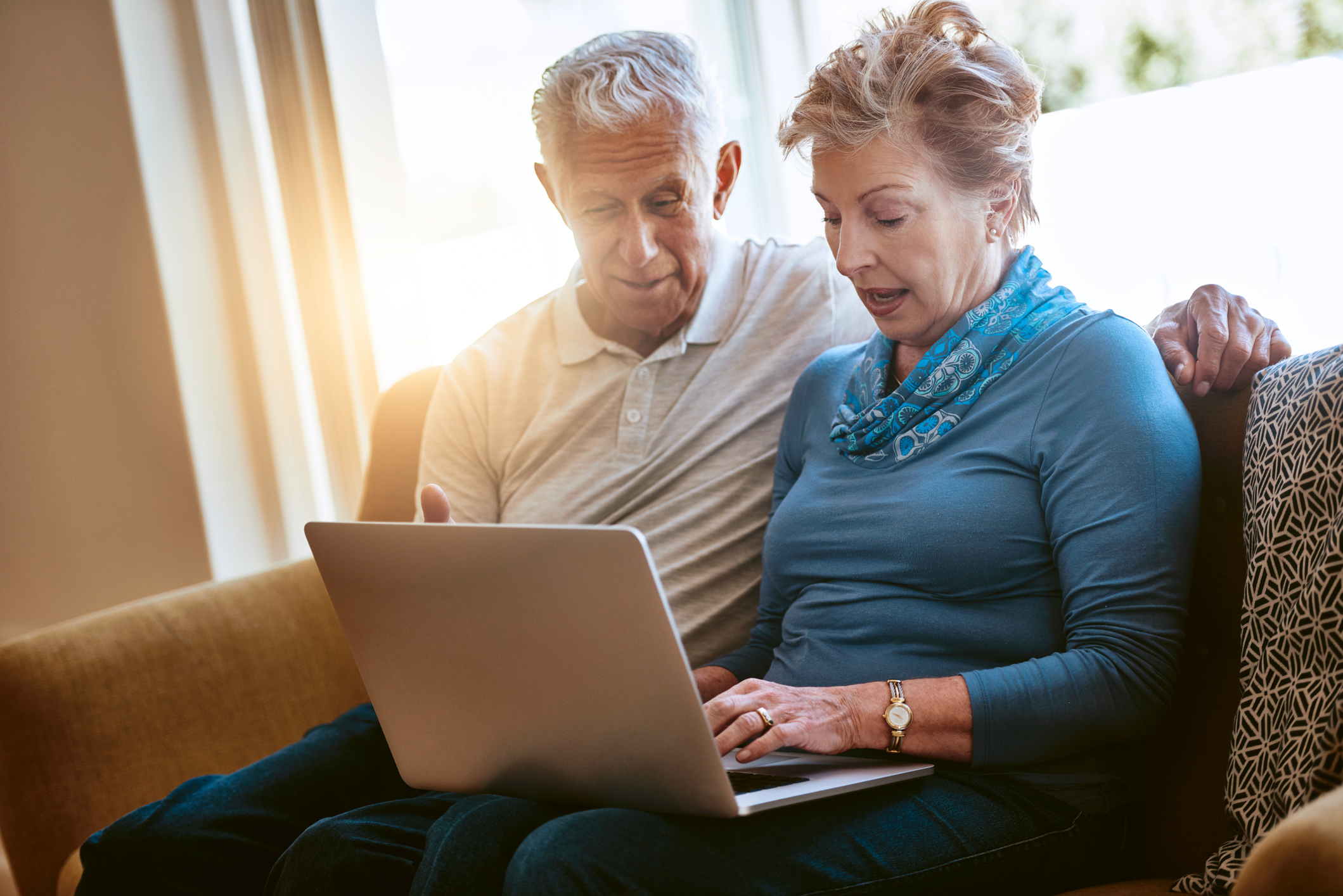Older couple sitting in front of a laptop computer researching trustworthy financial advisor websites www.paladindigitalmarketing.com