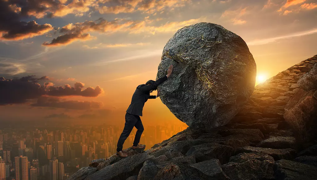 financial advisor struggling to roll a boulder up a mountain as a metaphor for obtaining qualified leads